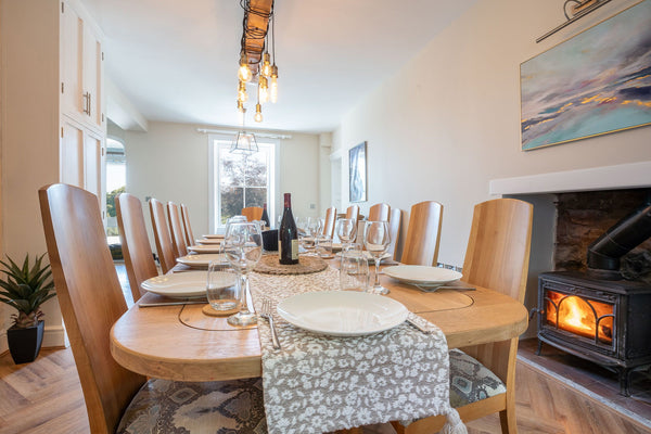 Shared dining table and fireplace at Bron Menai