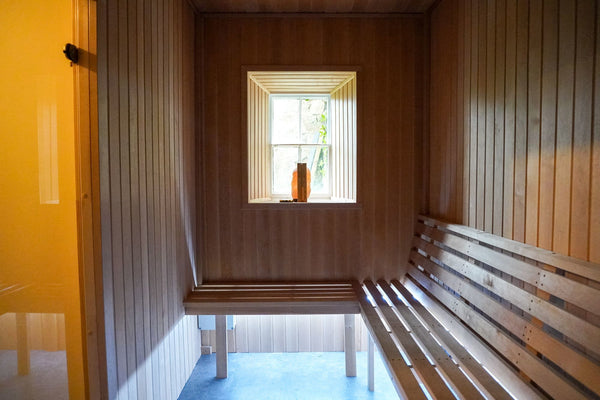 Wood-lined sauna with bench seating at Bron Menai